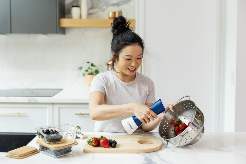 Persona usando iClean mini para lavar frutas en su cocina